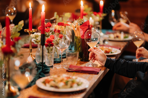 Photos Elegant candlelit dinner with wine and gourmet salad at festive celebration tabl