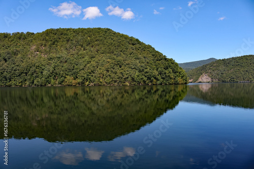 mountain reflection on a lake with blue sky and clouds