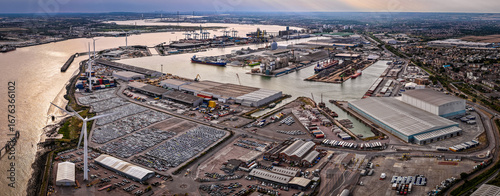 Wide-angle aerial image of the Port of London, showing industrial shipping activity, warehouses, and container docks. Ideal for logistics, maritime trade, transport, economy, and infrastructure themes