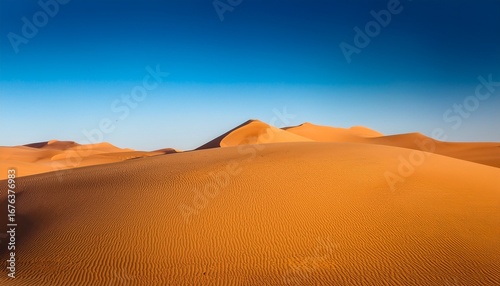 golden sand dunes under clear blue sky stretching across horizon in minimalist composition
