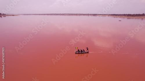 SENEGAL - 7.14.2025 - Fantastic aerial view of a man rowing a boat across Dakar, Senegal's Pink Lake.