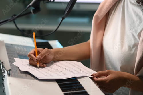 Young woman writing on note...