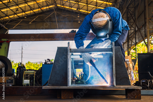 Industrial welder welding fabricated construction in factory, Welding process by Flux Core Welding, FCAW