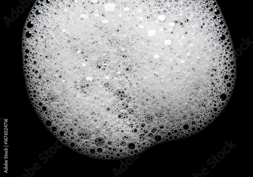 Soap bubbles and water drops on black background with blue and white textures