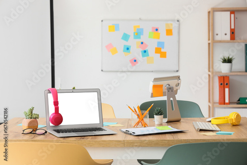 Table with blank laptop, he...