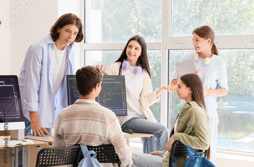 Teenage students talking at school computer lab