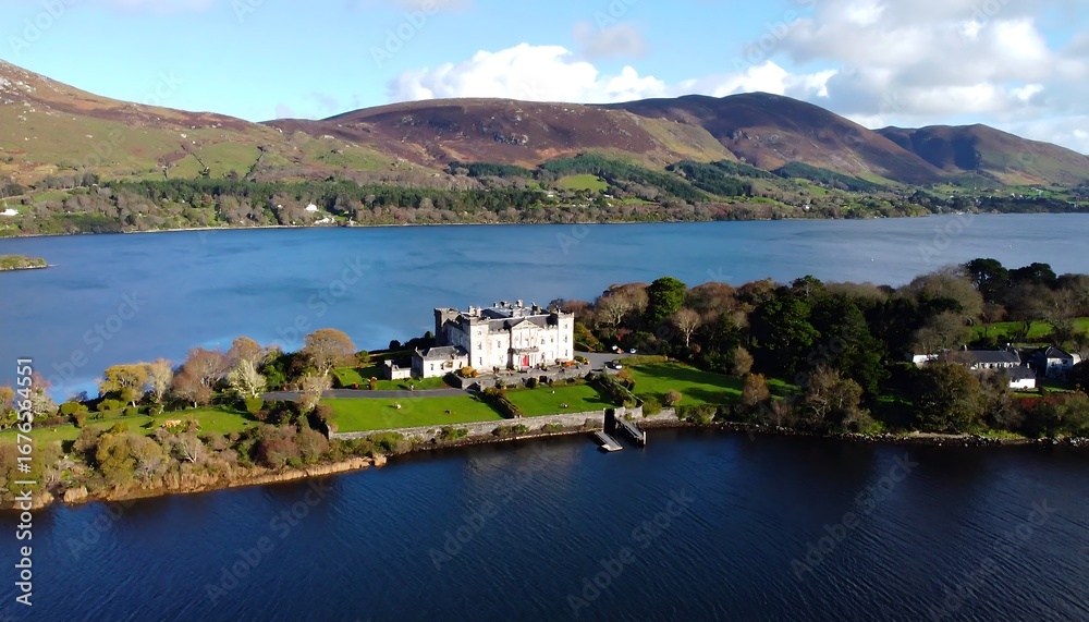 Fototapeta premium Panoramic view of a castle on a lake surrounded by hills