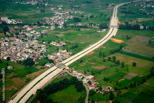 Modern Highway Cutting Through Rural Indian Villages and Farmland