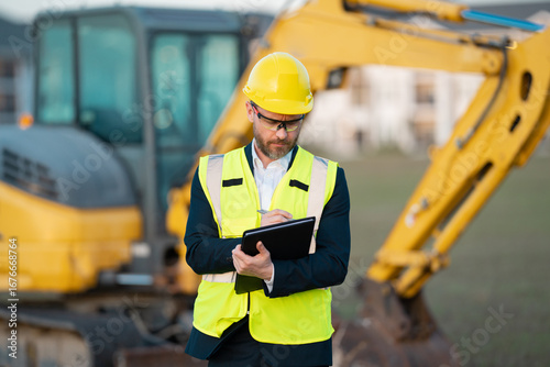 Worker in suit and helmet. Investor civil engineer, construction manager. Construction building developer at a construction site. Successful architect. Handsome hispanic builder man in suit.