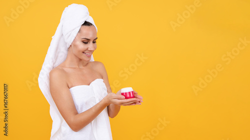 Beautiful woman with towel on head hold face cream. Cream your skin, facial care. Facial cream. Fresh and clear skin, skincare routine. Beauty cream cosmetology. Perfect skin of beauty girl. Beauty
