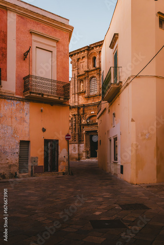 Fototapeta Naklejka Na Ścianę i Meble -  Historic street in Nardò leading toward baroque church facade