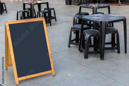 Wallpaper Mural Empty chalkboard next to tables and chairs and a food truck in a square in Brazil Torontodigital.ca
