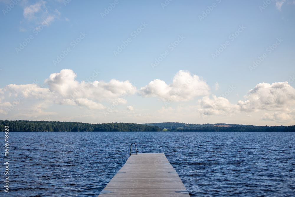 Obraz premium Wooden Pier Extending Into Molkomssjön Lake in Molkom, Sweden on a Summer Day