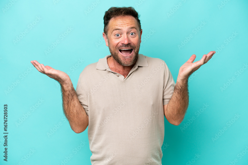 Fototapeta premium Middle age caucasian man isolated on blue background with shocked facial expression