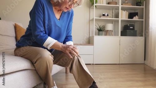 Elderly woman suffering from knee pain at home