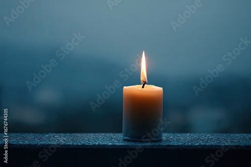 Single candle flame at dusk