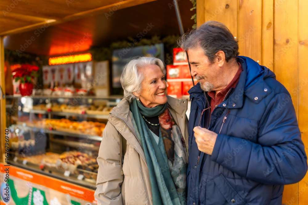 Fototapeta premium Happy senior couple enjoying christmas market festivities