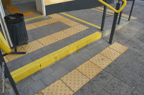 Quadro su tela accessibility ramp with yellow railings and tactile paving for visually impaired