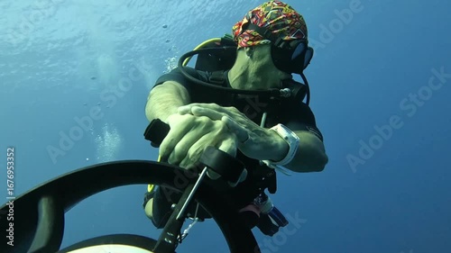 Extreme underwater hobbies. A diver rides an underwater scooter.