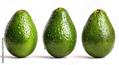 Three ripe avocados, glistening with water droplets, arranged in a horizontal row against a white background © Irfan