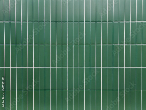 Green tile wall background with clean geometric pattern. Ceramic surface design suitable for interior, bathroom, kitchen, architecture, and decorative concepts.