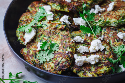 Green zucchini pancakes with feta and cilantro. Vegetarian breakfast recipe.
