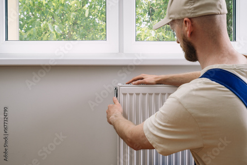 Home heating radiator maintenance by a professional in a sunny room