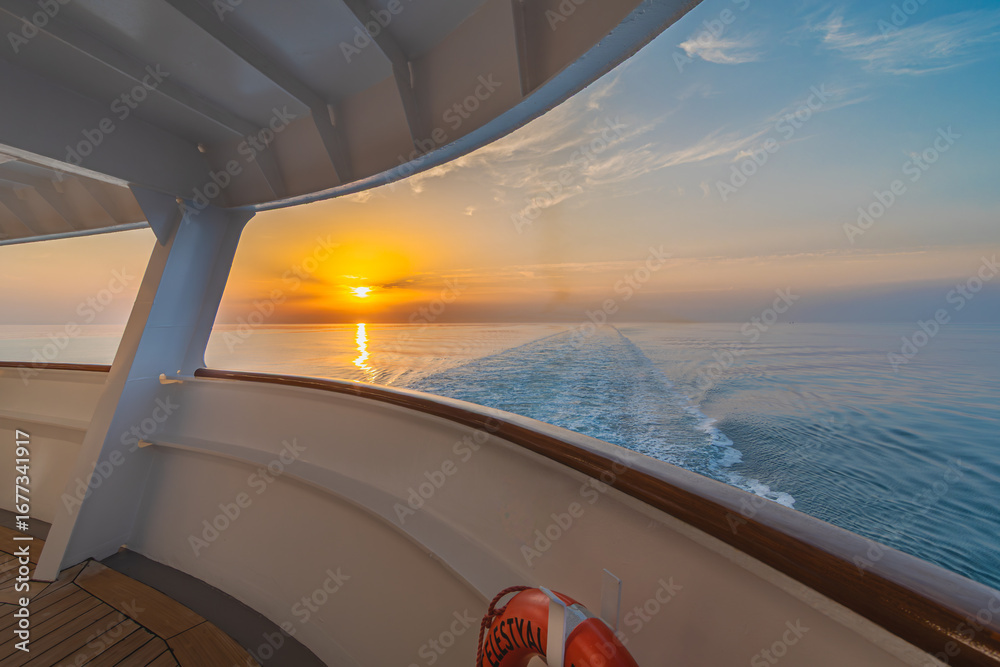 Fototapeta premium Coucher de soleil dans le sillage d'un navire de croisière en navigation.