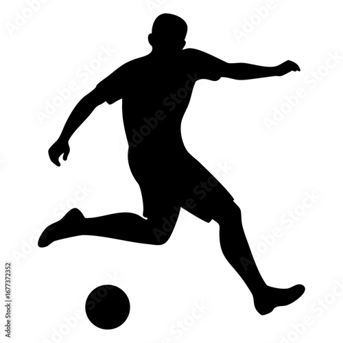 Shadowed figure of a soccer player kicking a ball