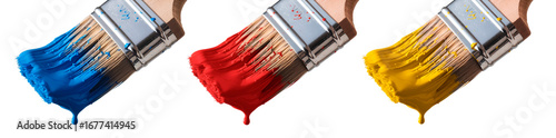 Paintbrushes covered in blue, red and yellow paint arranged in row on white background