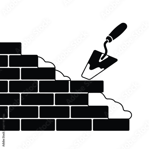 Bricklaying process with trowel and mortar on bricks.