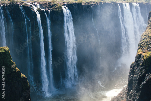 Stunning waterfall plunging down a rugged cliff face in a scenic landscape.