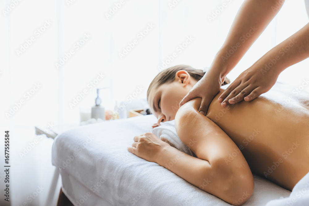 Fototapeta premium Caucasian woman customer enjoying relaxing anti-stress spa massage and pampering with beauty skin recreation leisure in day light ambient salon spa at luxury resort or hotel. Quiescent