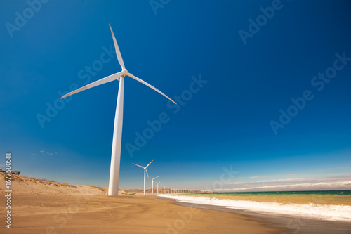 Wind turbines along ocean shore — sustainable and renewable energy landscape