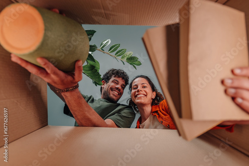 Photos Happy couple unpacking cardboard box in new home