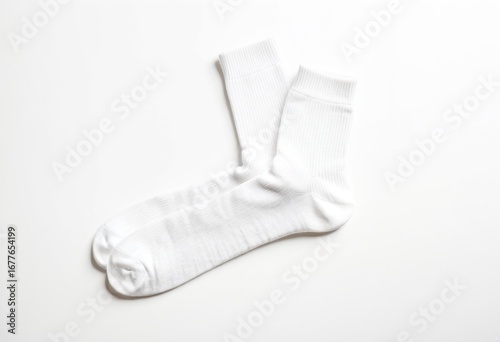 A pair of white socks on a white surface.
