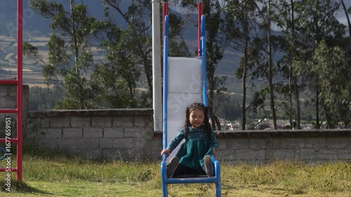 Young girl repeatedly enjoying slide in playground