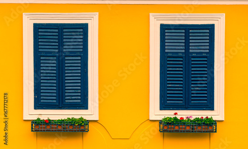 Dark Blue Wooden Shutters on Bright Yellow Wall