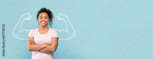 Obraz na plátne A confident African American woman stands with crossed arms, smiling against a blue background