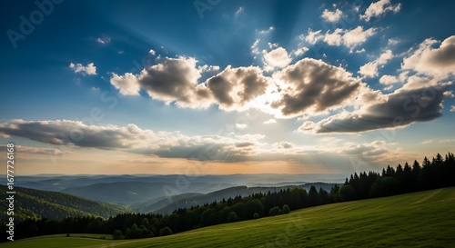 Golden hour light over rolling hills and cloudy sky at sunset.