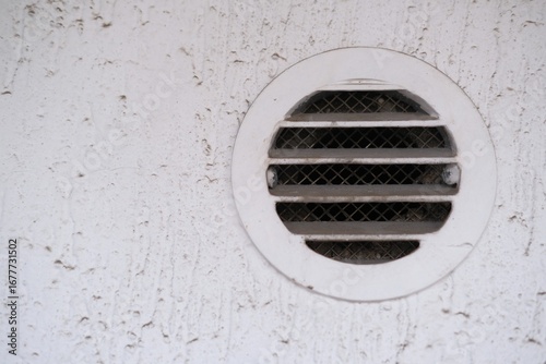 White round dirty and dusty air vent panel on wall of residential building. Ventilation and temperature regulation. Maintenance of household, interior or exterior air grille. Cleaning services