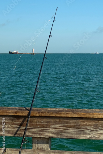 A Fishing Pole Rests On Pier Overlooking Ocean
