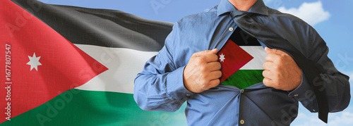 A businessman opening his shirt like super hero with Jordan flag and shows how patriotic he is by revealing his countries flag beneath printed on a t-shirt.