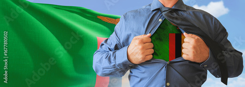 A businessman opening his shirt like super hero with Zambia flag and shows how patriotic he is by revealing his countries flag beneath printed on a t-shirt.