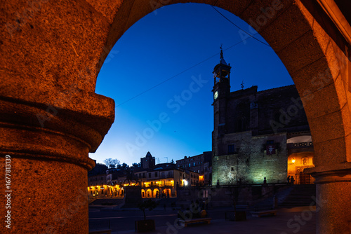 San Martin Church illuminated at dusk framed by plaza mayor arch