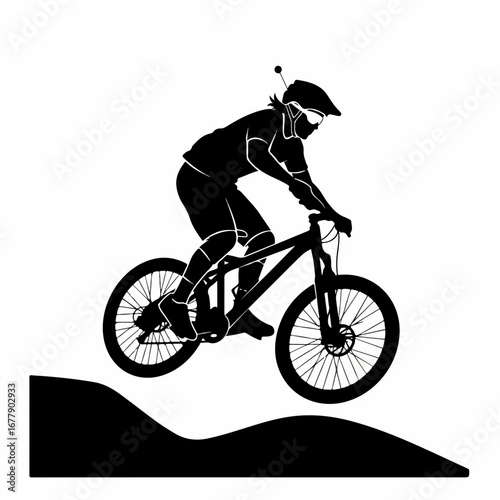 Silhouette of a mountain biker jumping on a dirt trail.