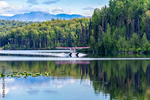Fotografía Small floatplane landing on the lake surrounded by the forest