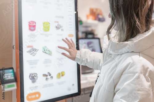 Bild auf Leinwand A woman is interacting with a digital menu displayed at a modern retail store today