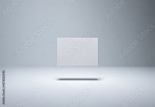 A clean and modern mockup featuring a single blank white business card levitating in a seamless gray studio environment for branding presentation