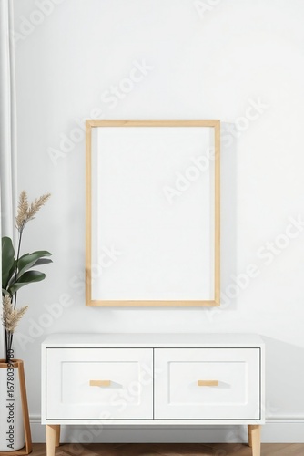 Blank square picture frame mockup on a white wall above a modern cabinet